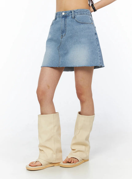 Casual Denim Mini Skirt CU522 in light blue, side view on model from waist down, A-line cut with raw frayed hem, paired with cream leather fold-over sandal boots.