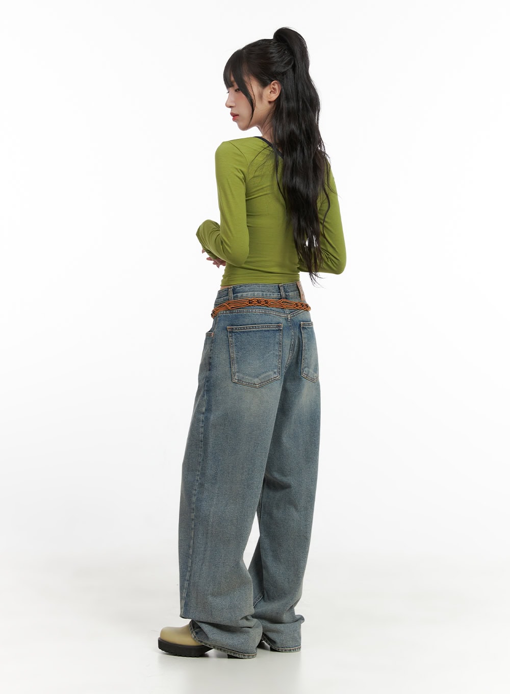 Millie Washed Baggy Jeans CG421 in Blue, full-body back view on model, wide-fit washed denim with back pockets and braided belt detail, styled with green crop top and chunky boots.