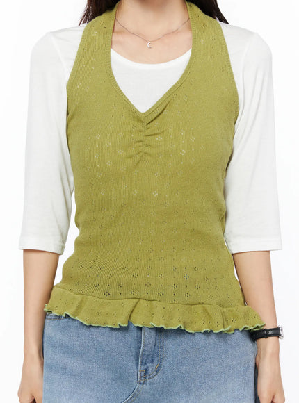 Frill Hem Halter Neck Top CU522 in green, torso close-up on model, showing ruched V-neckline, pointelle knit texture, and ruffled frill hem, layered over white 3/4-sleeve top with blue jeans.