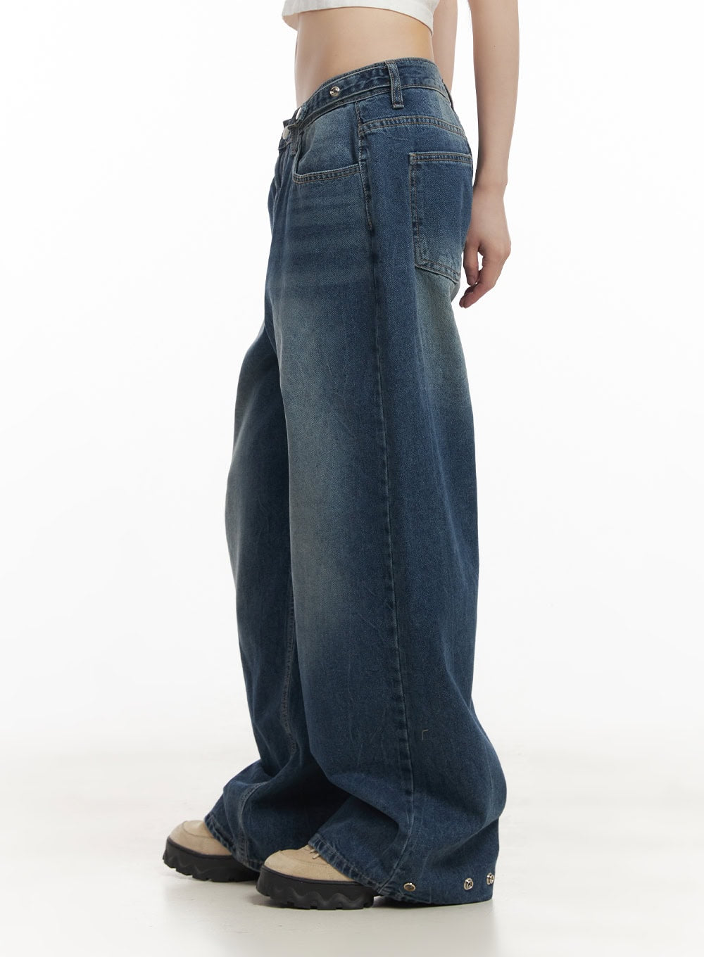 Bri Oversized Buttoned Baggy Jeans CF518 in dark blue, side view on model, low-rise waist with tab closure, oversized wide-leg silhouette pooling at hem, white crop top.