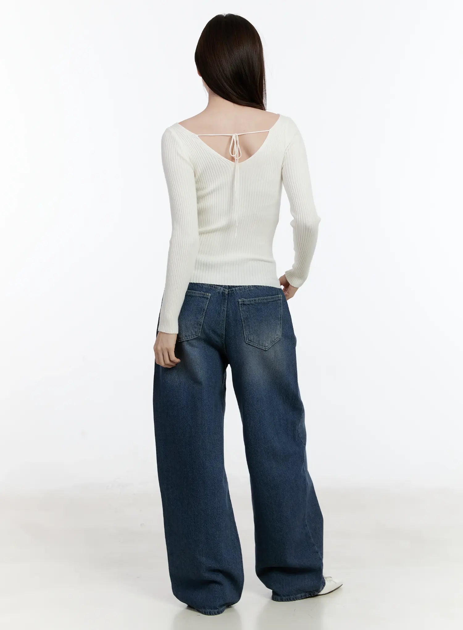 Della Casual Denim Wide Jeans ID511 in blue, back full-body shot on model, washed wide-leg cotton denim showing rear pockets, paired with cream ribbed back-tie knit top and white flats.
