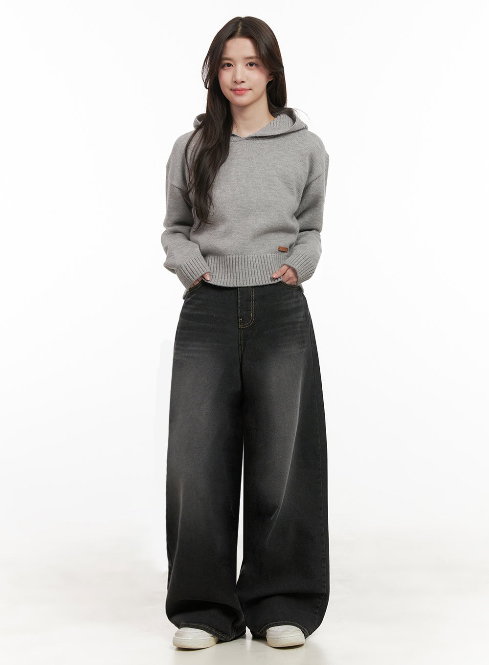 Christina Washed Baggy Jeans IJ510 in black, full-body front shot on model standing straight, wide-fit washed denim paired with cropped grey knit hoodie and white sneakers.
