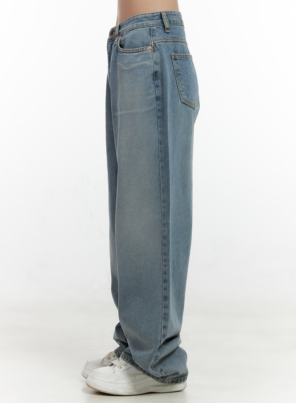 Taryn Chic Wide-Leg Jeans ON404 in light blue, side view from waist down on model, washed denim with wide-fit silhouette, back pocket visible, stacked at white sneakers.