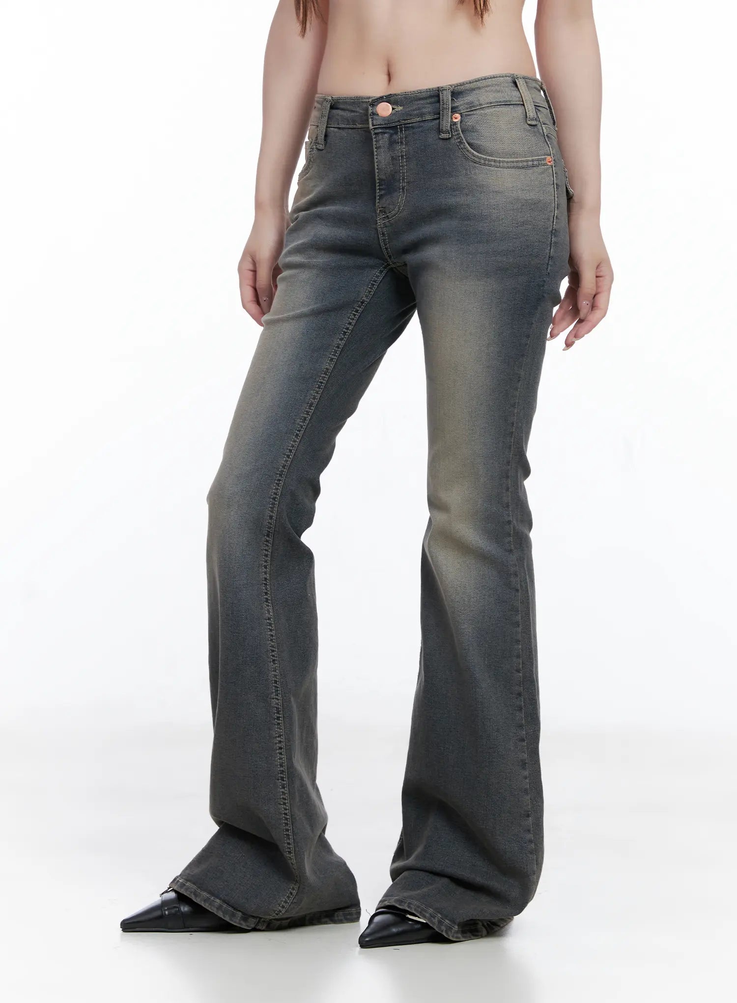 Sumin Low-Rise Flare Hip Pad Jeans CG529 in gray, side view on model, washed flare silhouette with tight thigh fit flaring at hem, rose gold hardware, black pointed flats.