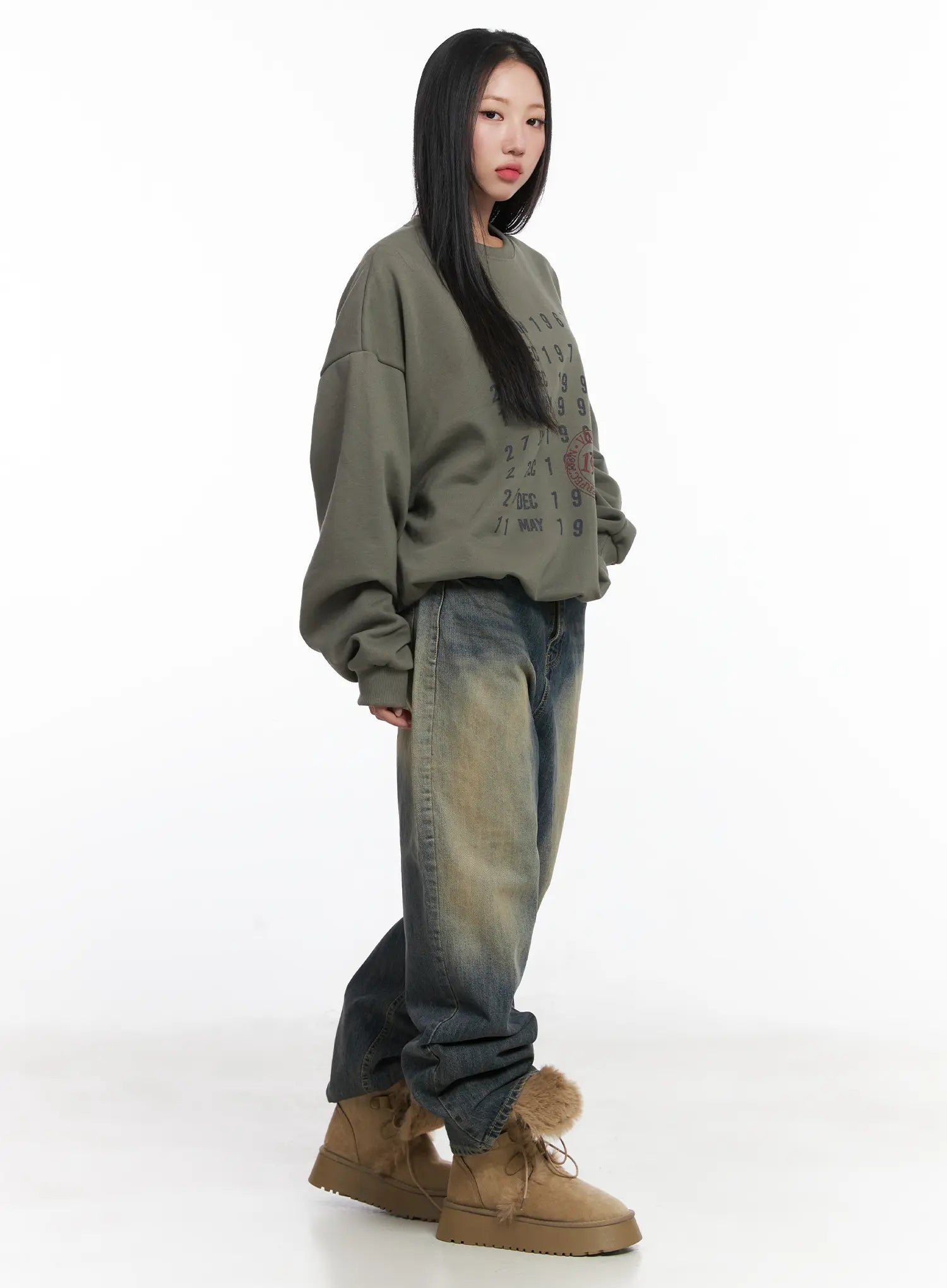 Wide Washed Jeans CS06 in vintage blue, side-angle full-length shot on model, wide-leg cotton denim showing sandy wash gradient down the leg, paired with olive sweatshirt and tan fur boots.