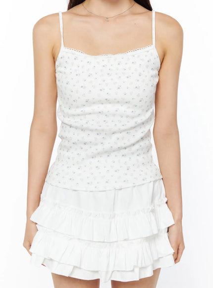 Floral Ribbed Cami Top CU522 in white, front close-up torso shot on model, square neckline with delicate lace trim, ditsy floral ribbed fabric, paired with white tiered ruffle skirt.