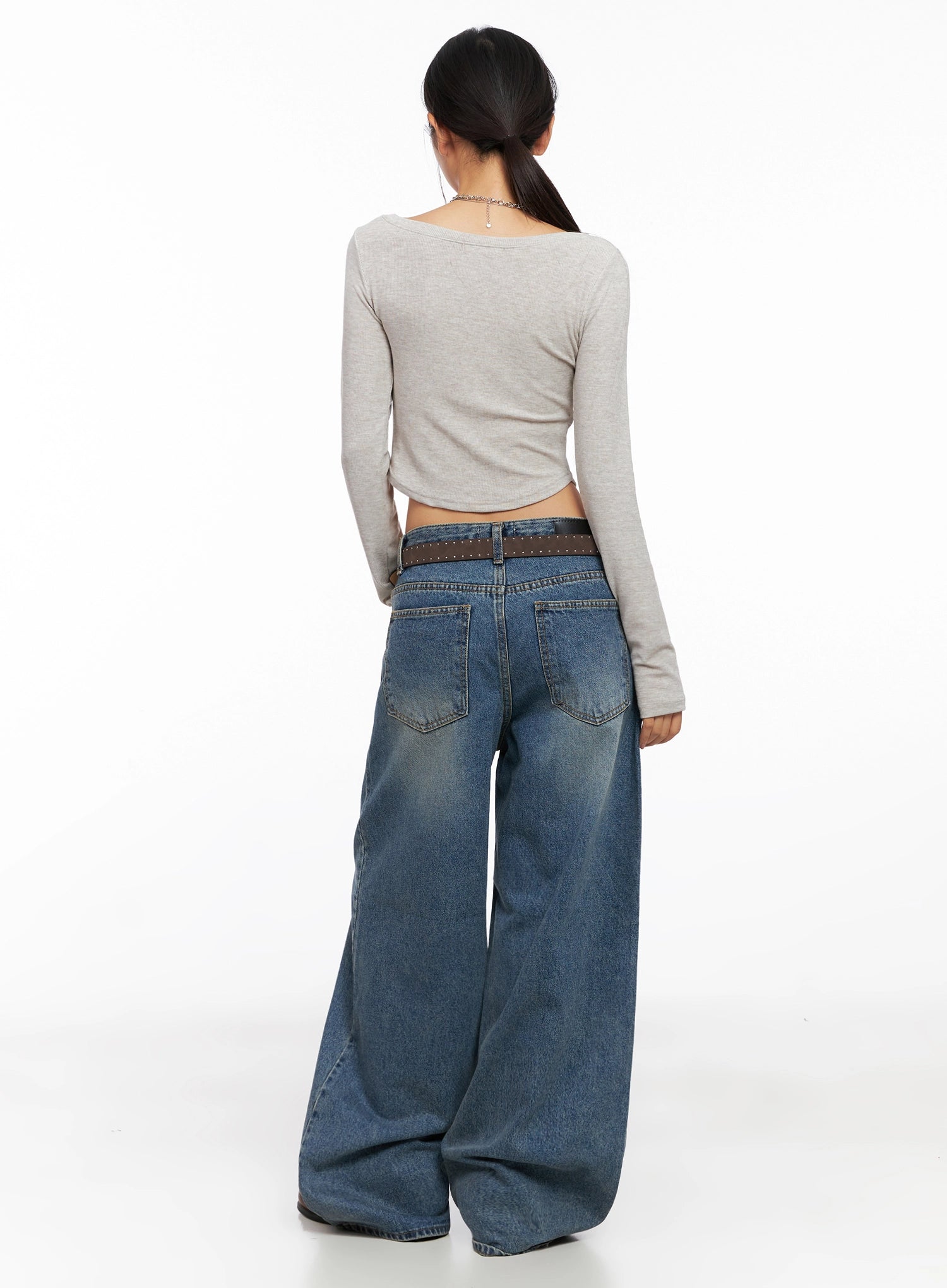 Lilah Wide-Leg Washed Jeans IG527 in mid-blue, back view on model, dual back pockets and washed fading visible, paired with beige crop top and studded belt.