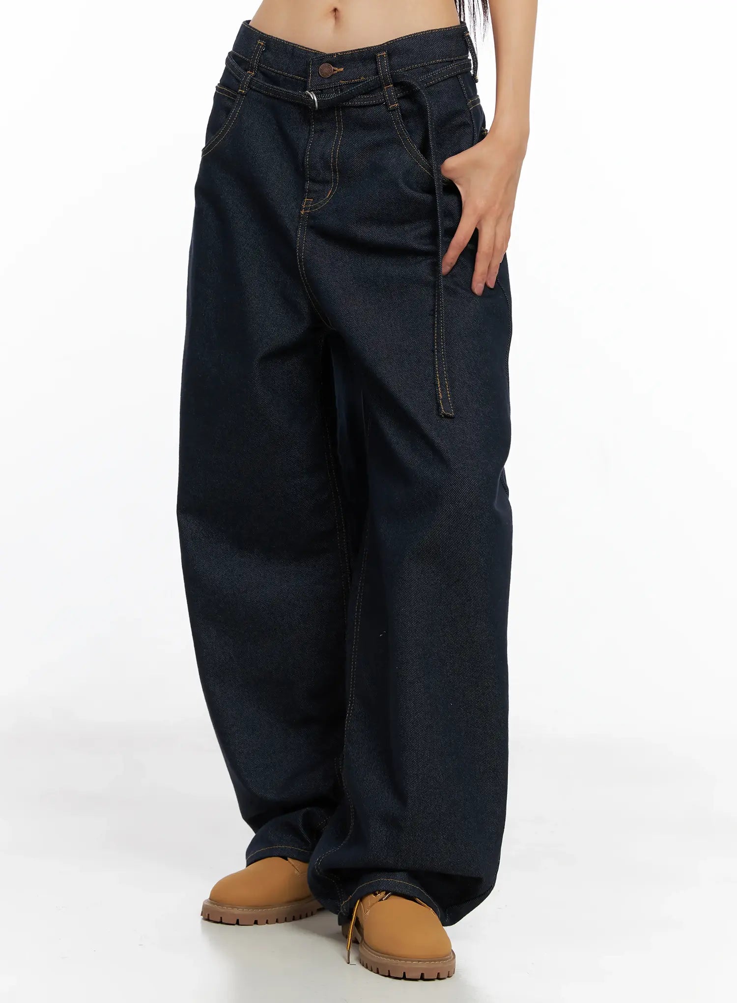 Alanna Sun Belt Baggy Jeans CO528 in dark indigo, side view on model, loose wide-leg cotton denim with low rise, contrast stitching, and belt detail, paired with tan chunky shoes.