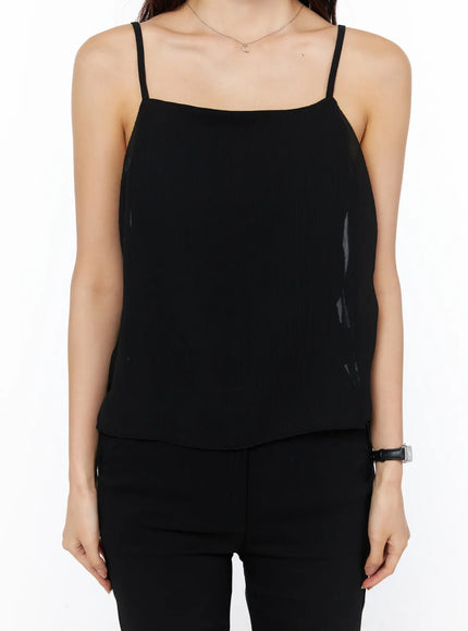 Sheer Ribbon Cami Top CU522 in black, cropped front close-up on model, square neckline, thin spaghetti straps, sheer crinkle fabric, paired with black trousers.