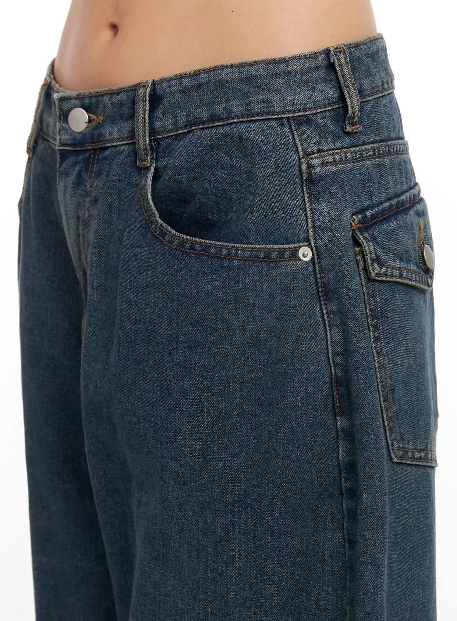 Aleena Mid-Wash Baggy Jeans IN528 in dark blue, close-up detail of front pocket area showing silver button hardware, contrast orange stitching, and washed cotton denim texture.