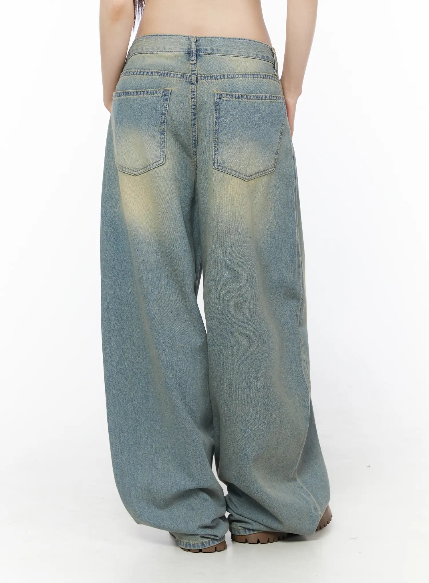 Rain Vintage Washed Wide Leg Jeans CU519 in light blue, back view on model, dual back pockets with yellow vintage wash fading, voluminous wide leg silhouette, hem gathered at floor.