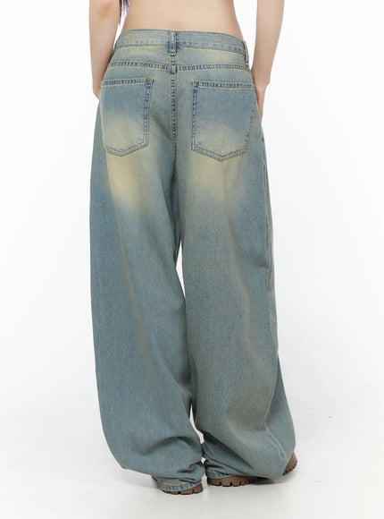 Rain Vintage Washed Wide Leg Jeans CU519 in light blue, back view on model, dual back pockets with yellow vintage wash fading, voluminous wide leg silhouette, hem gathered at floor.