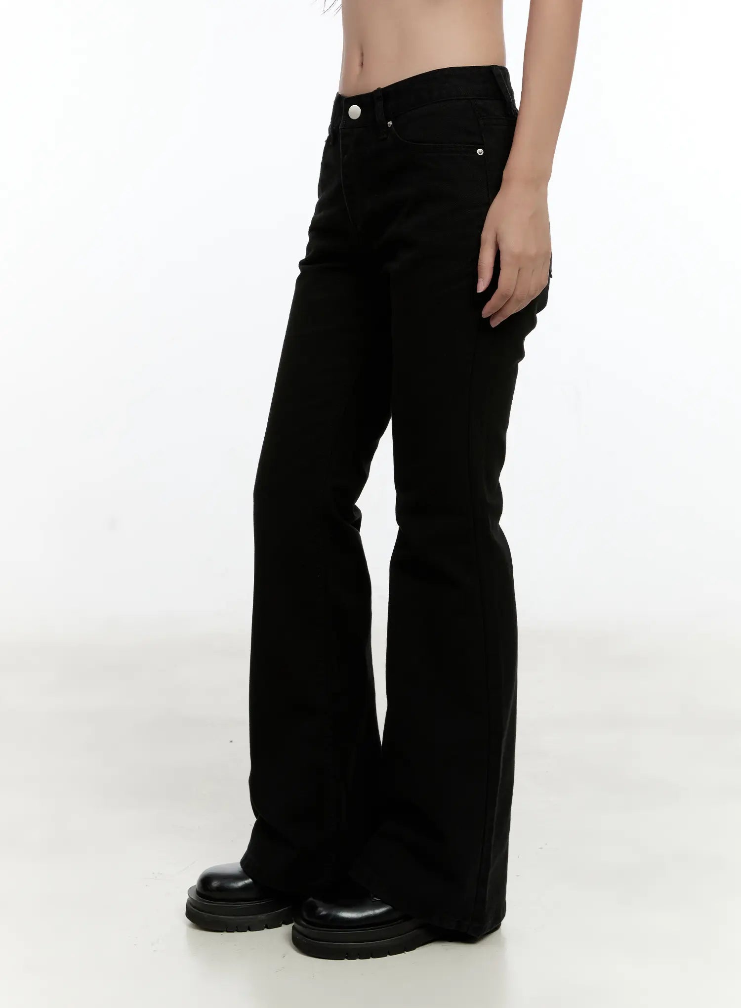 Classic Flare Pants CL531 in black, side close-up on model, waist-to-hem view highlighting bootcut flare silhouette, silver button detail, and smooth cotton fabric.