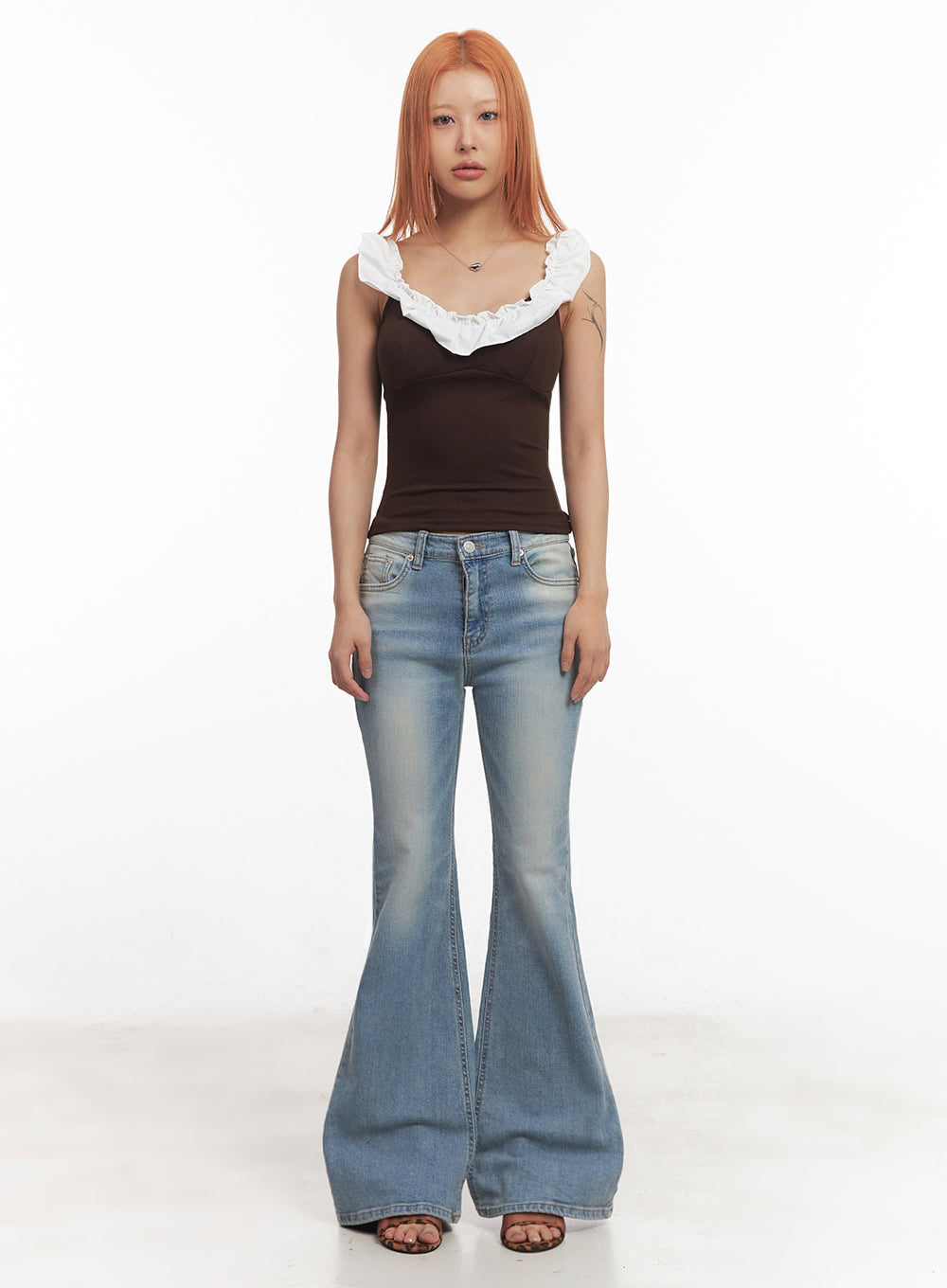 May Washed Flared Jeans IA515 in light blue, full-length front shot on model, wide flared hem and slim thighs visible, washed cotton-spandex denim, styled with brown crop tank top.