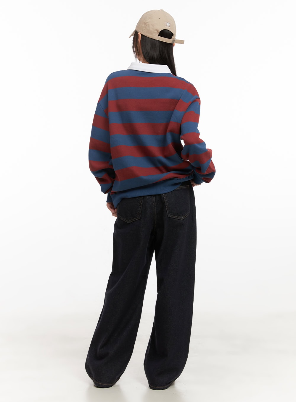Allie Stitched Wide-Leg Jeans CD430 in dark blue, back full-body view on model showing rear patch pockets with contrast stitching, styled with striped sweatshirt and cap.