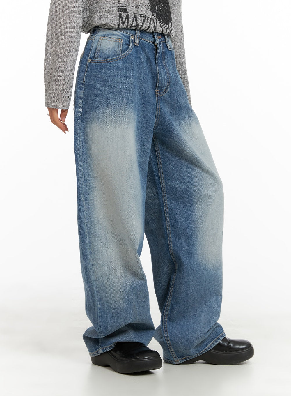Comfy Wide Fit Baggy Jeans CA408 in blue, side view on model, oversized wide-leg silhouette with faded wash and roomy thigh, paired with gray graphic knit and black chunky shoes.