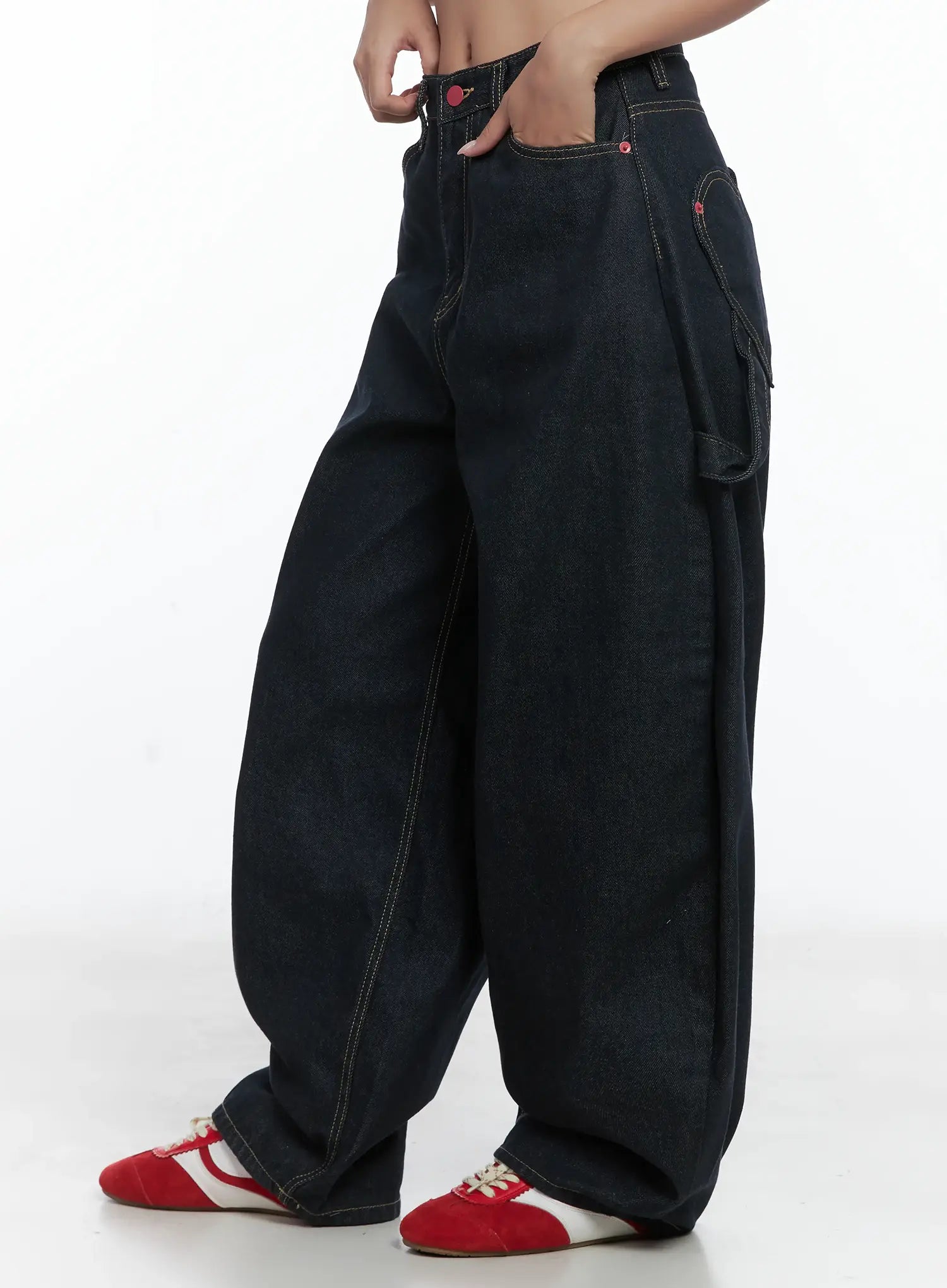 Heart Pocket Balloon Jeans CS503 in dark indigo, side close-up on model, exaggerated balloon leg silhouette, cargo side pocket detail, red rivets and yellow contrast stitching visible.