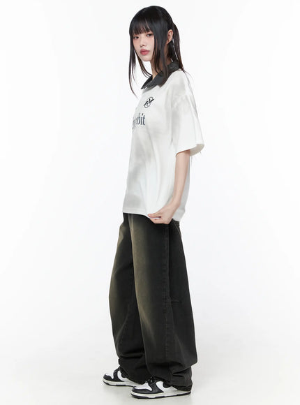 Oversized Collar Jersey CU519 in white, side view on model standing, oversized boxy silhouette with contrast dark collar visible, short sleeves, paired with wide-leg dark jeans and sneakers.