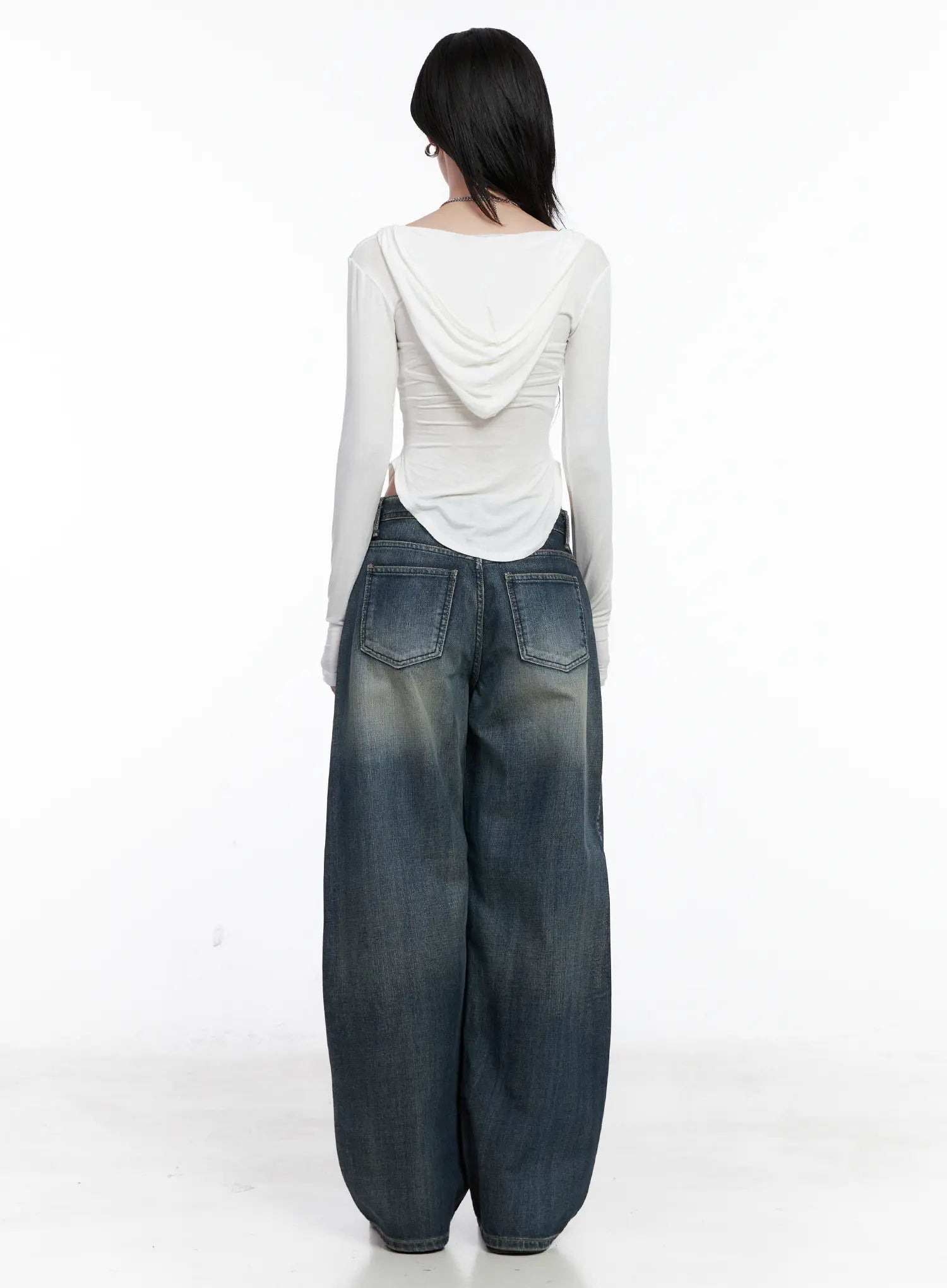 Nellie Baggy Jeans CS526 in blue, back view on model, showing dual back pockets with contrast stitching, washed finish and voluminous balloon-style leg, with white hooded top.