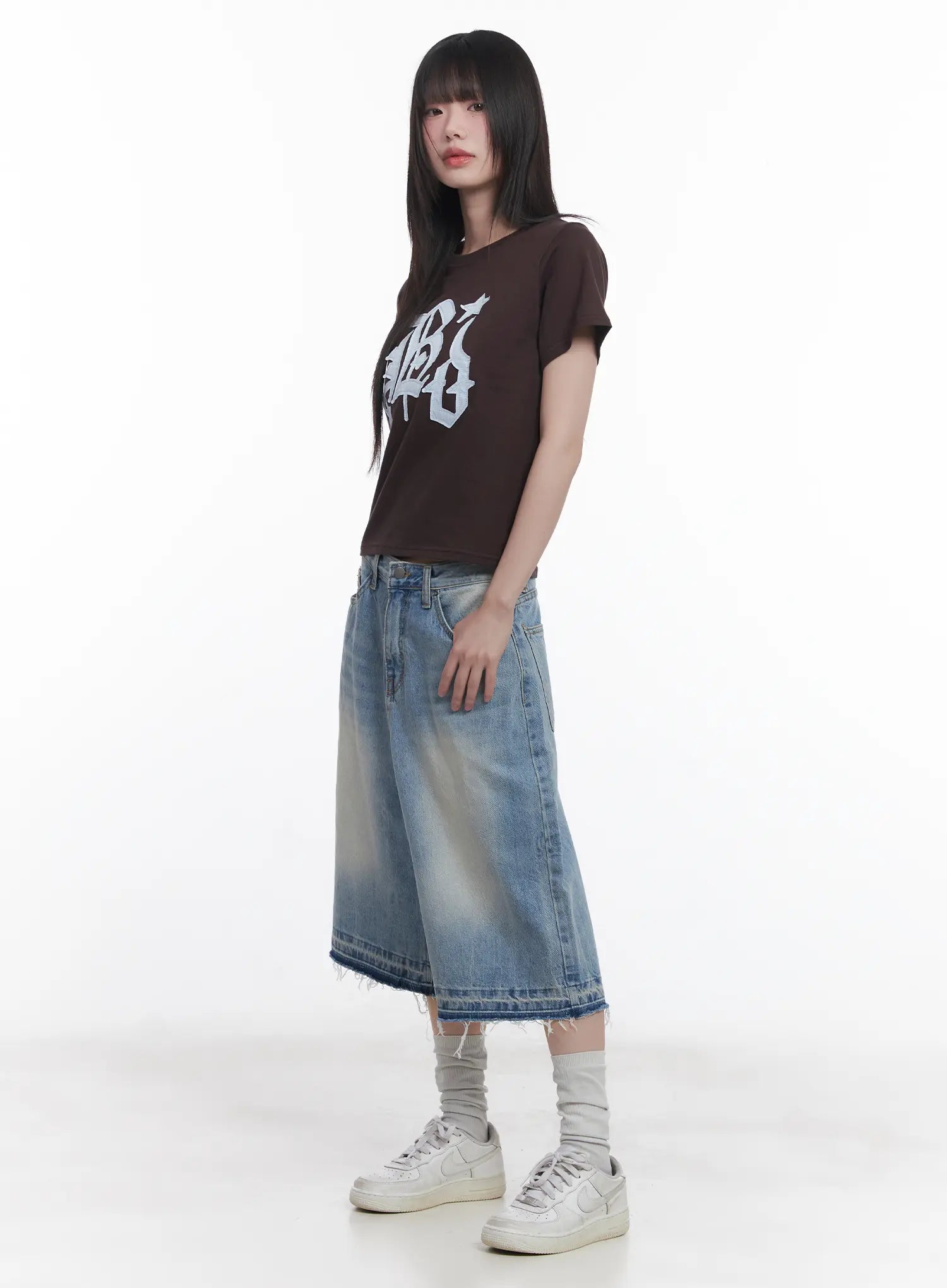 Light Wash Vintage Jorts CU519 in blue, side full-body on model, wide-leg midi length with raw frayed hem and vintage wash, paired with brown crop tee and white sneakers.