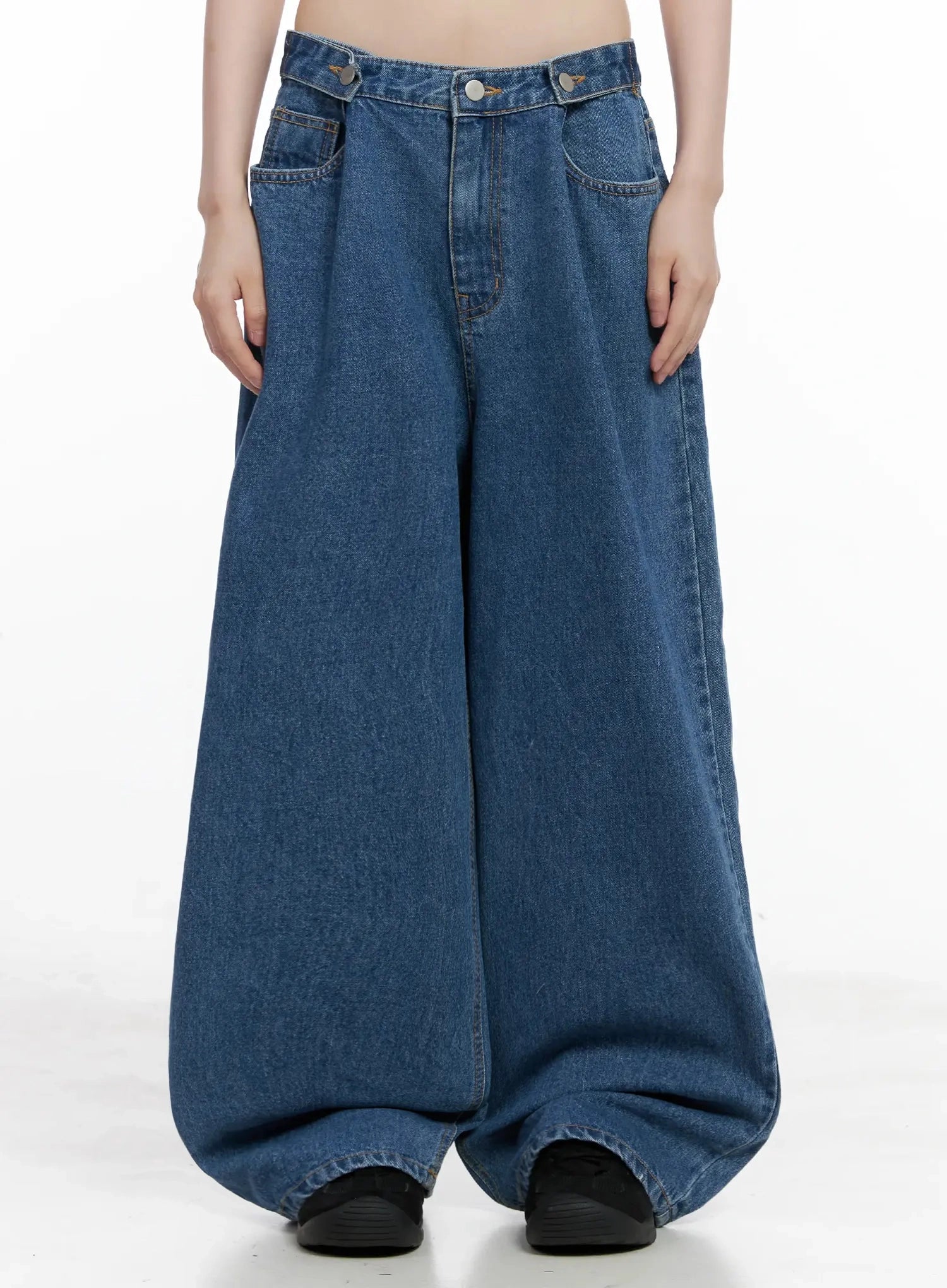 LEWKIN Pharita Loose-Fit Jeans IL528 in mid blue, front crop view on model, ultra wide-leg cotton denim with asymmetric waistband, deep front pockets, extra-volume hem pooling at floor.