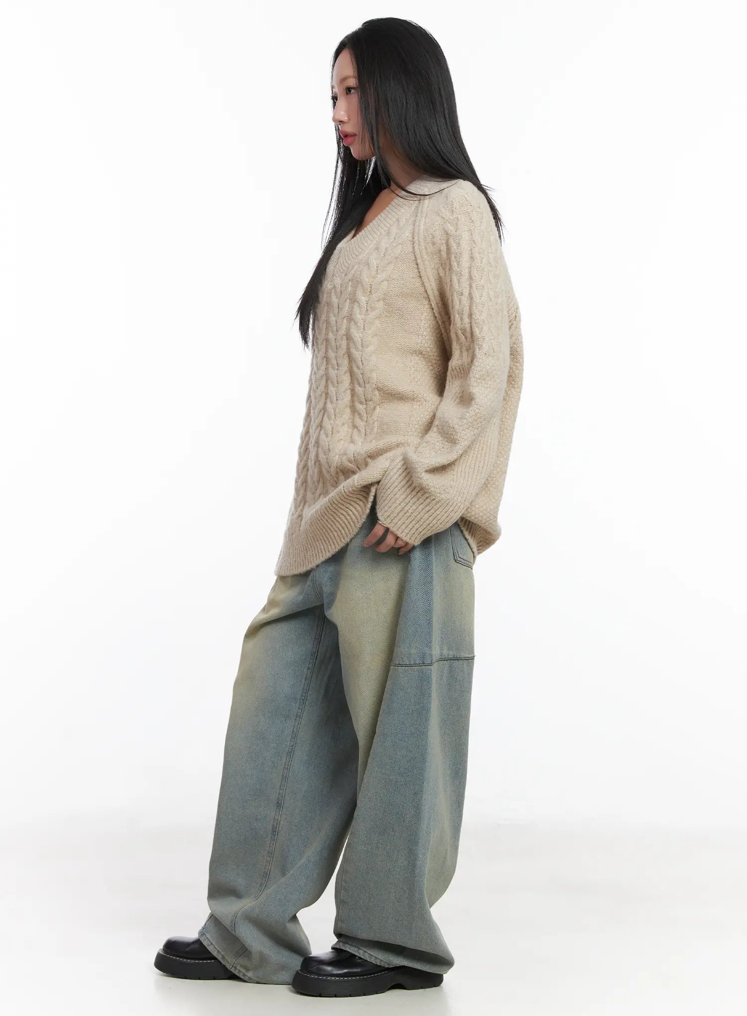 Lyla Washed Wide Leg Jeans CD530 in light blue, side view on model, wide leg silhouette with panel seam detail and yellow-tinted washed cotton denim, styled with beige knit sweater.