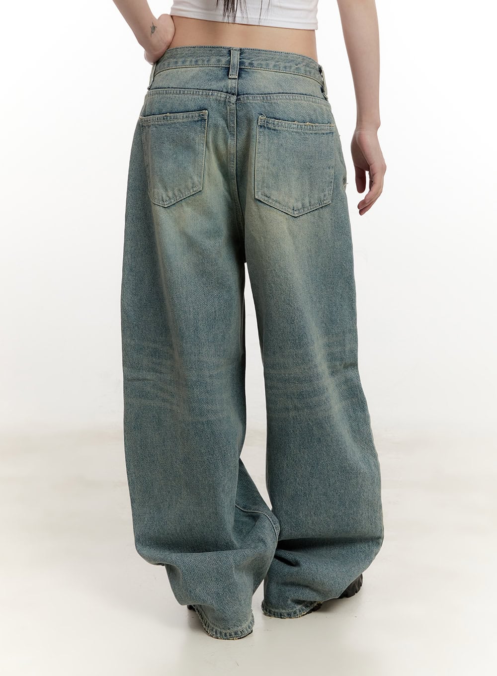 Galinda Washed Baggy Jeans CM513 in vintage blue, back view on model, two back patch pockets visible, yellow-toned washed denim, oversized wide leg pooling at floor.
