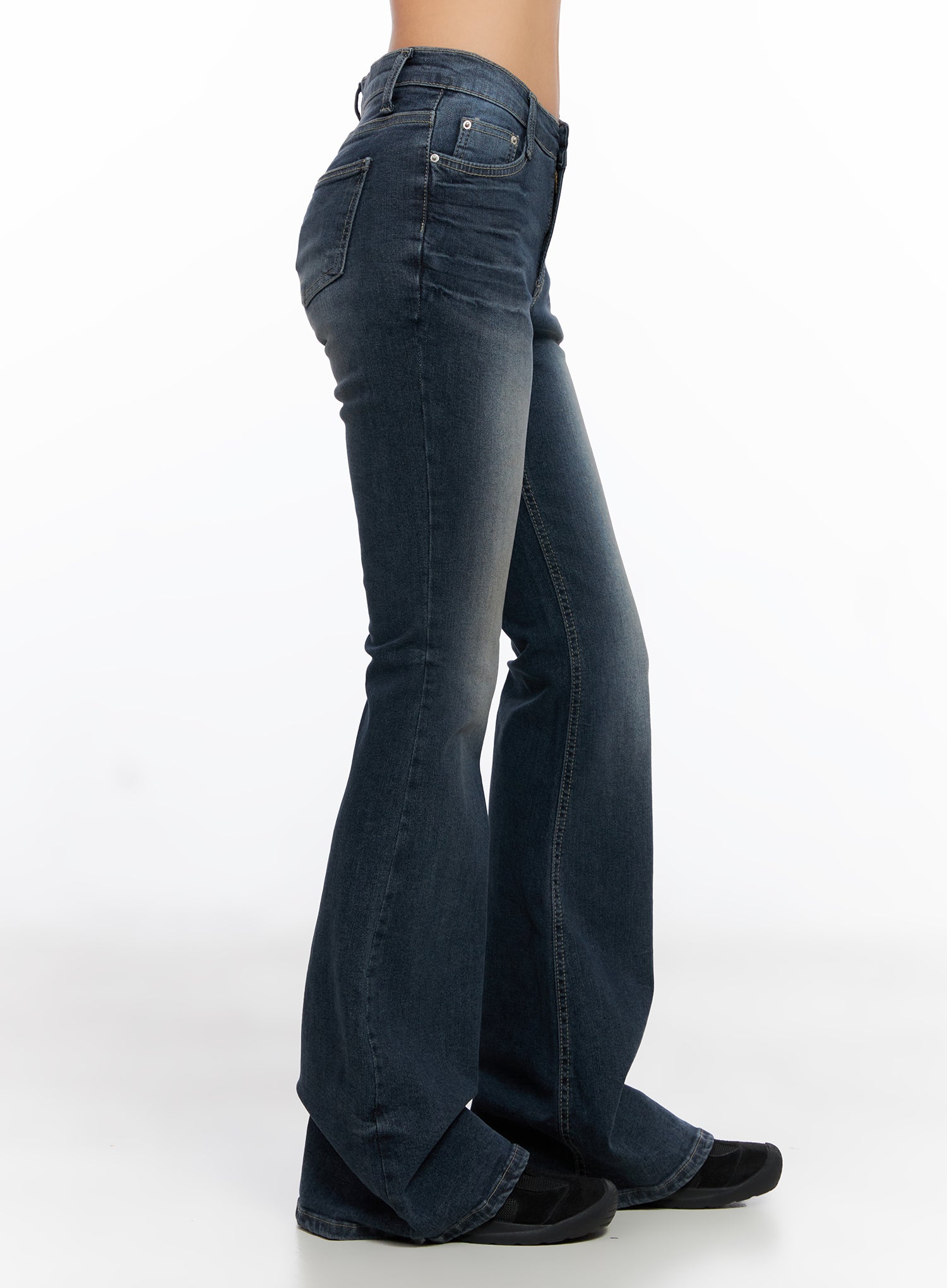 Melina Hip-Pad Low-Rise Flare Jeans CO514 in dark blue, side view product shot, showing slim thigh-to-flare silhouette, washed denim, and floor-length bell hem on model.