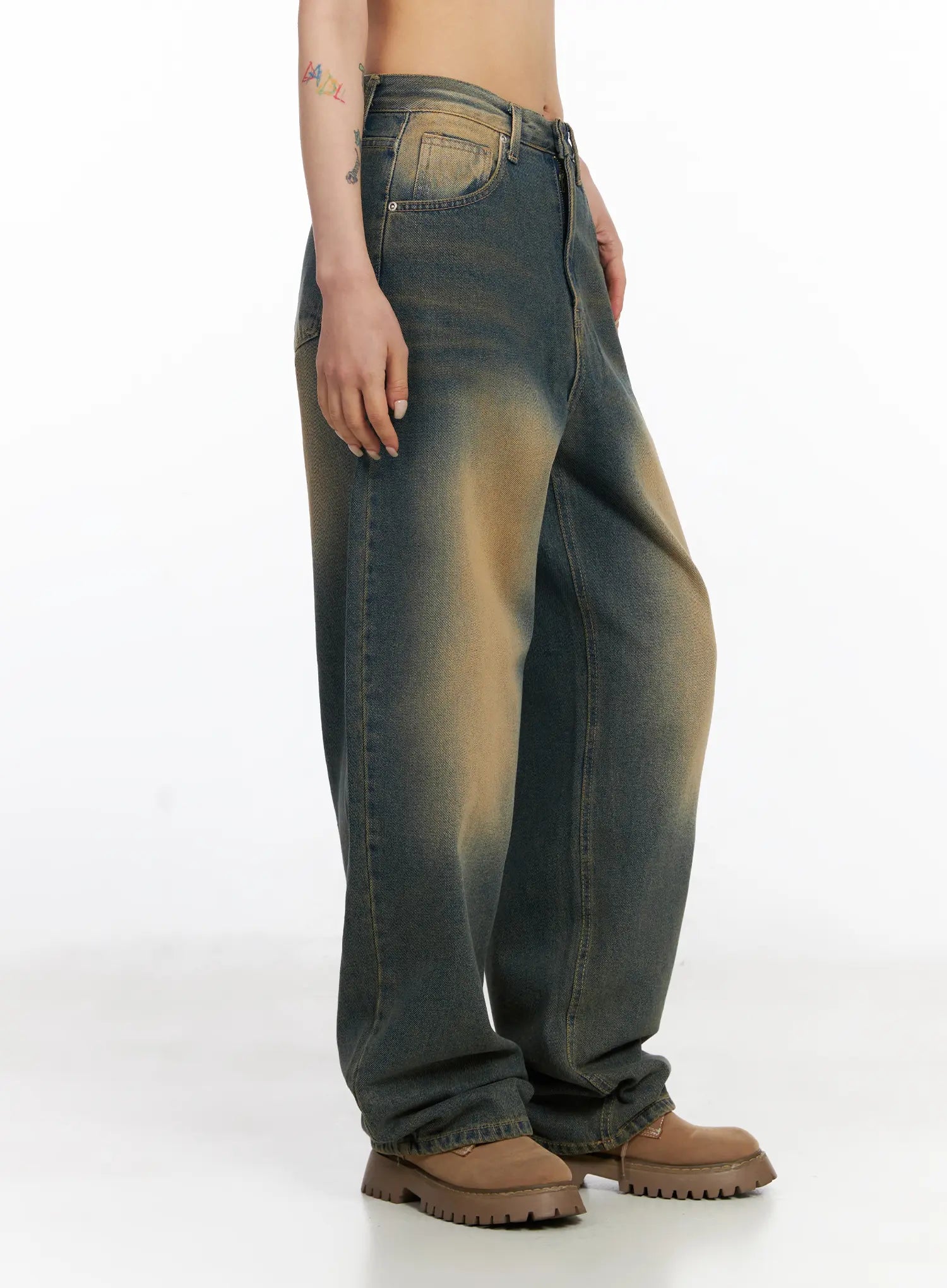 Karsyn Vintage Baggy Jeans CJ522 in dark blue, side view on model, highlighting wide baggy leg silhouette, vintage amber fade, and long length pooling over brown boots.