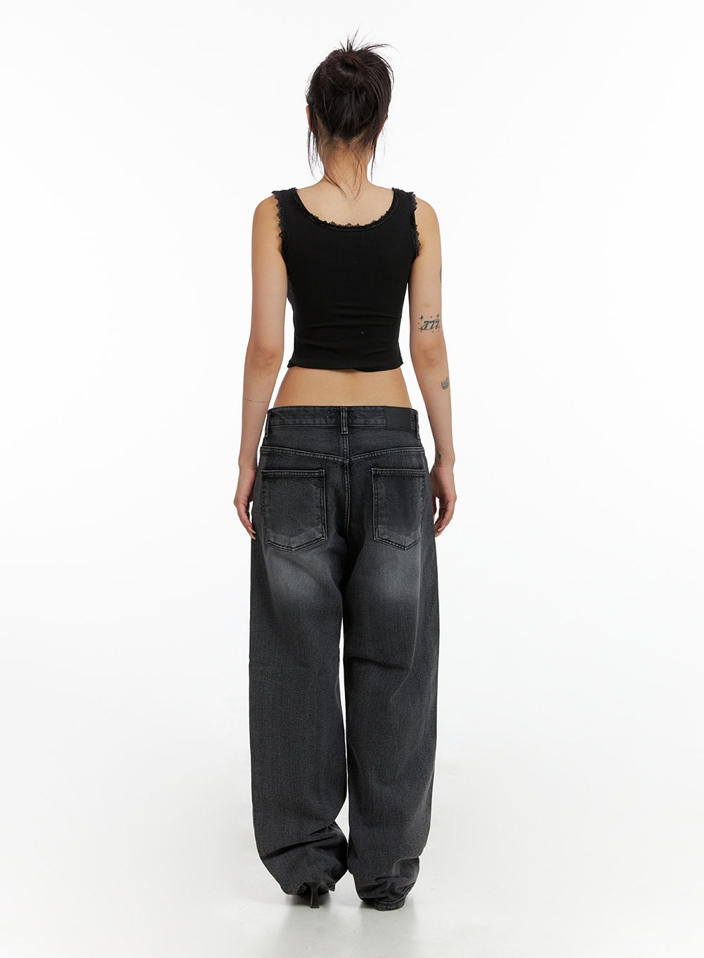 Low Rise Wide Leg Jeans CL415 in black, back view on model, dual back pockets with stitching, low waist washed denim wide leg, styled with black crop tank top.