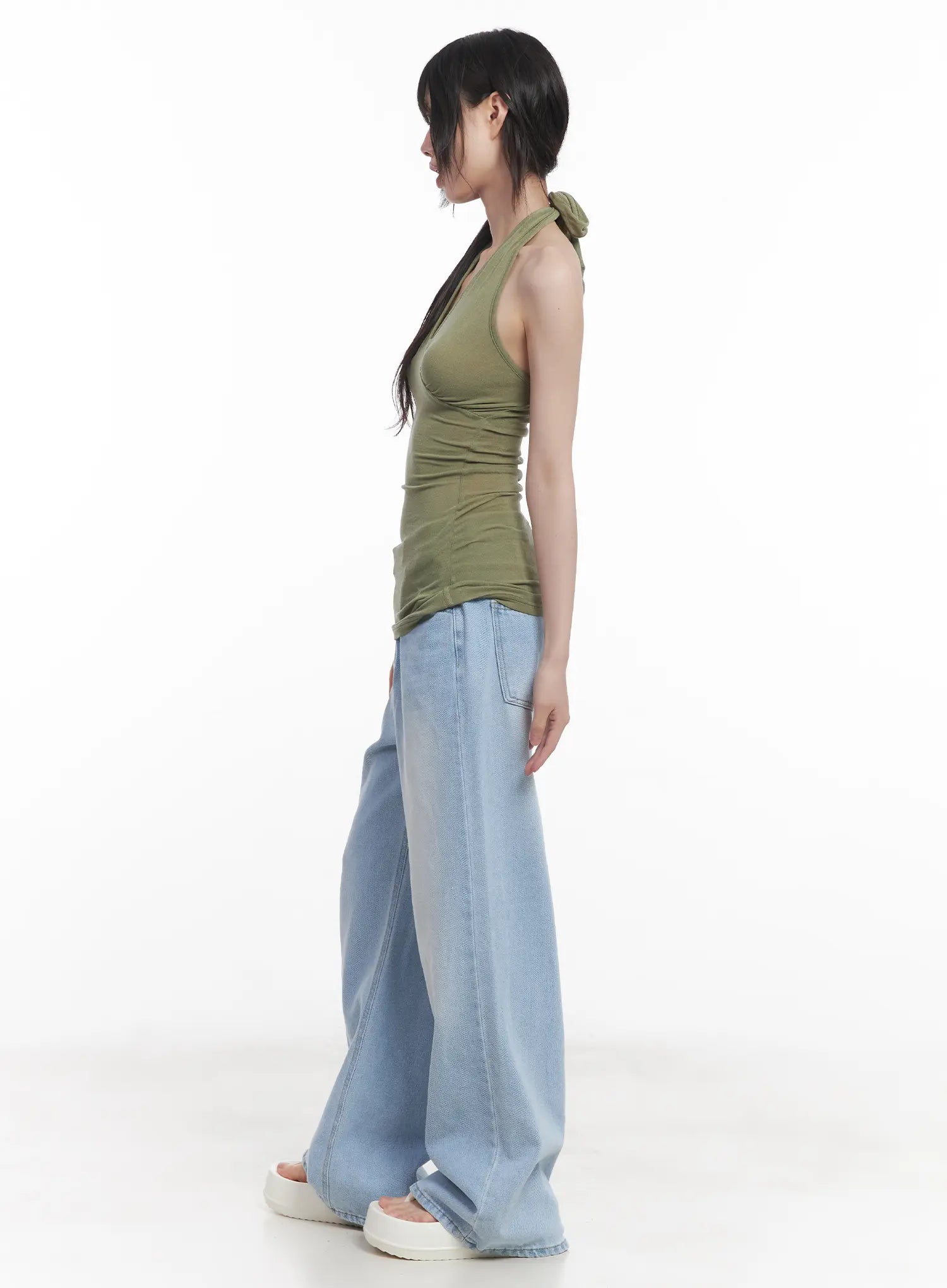 Haerin Washed Wide-Leg Jeans CU519 in light blue, side profile shot on model, straight wide-leg line with washed denim texture visible, styled with olive halter top and white sandals.