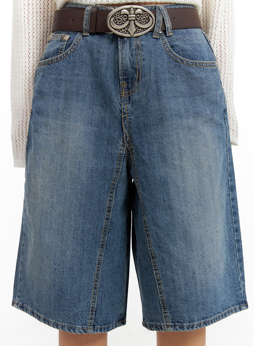 Vintage Washed Wide Leg Jorts CA415 in blue, front waist close-up on model, five-pocket denim with vintage wash, contrast stitching, and ornate engraved silver belt buckle detail.