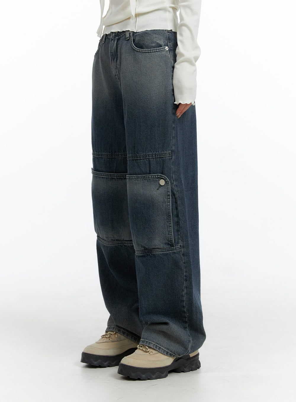 Denim Wide Leg Jeans CF408 in washed dark blue, close side view on model, highlighting horizontal panel seams and buttoned cargo pocket detail on wide-fit denim leg.