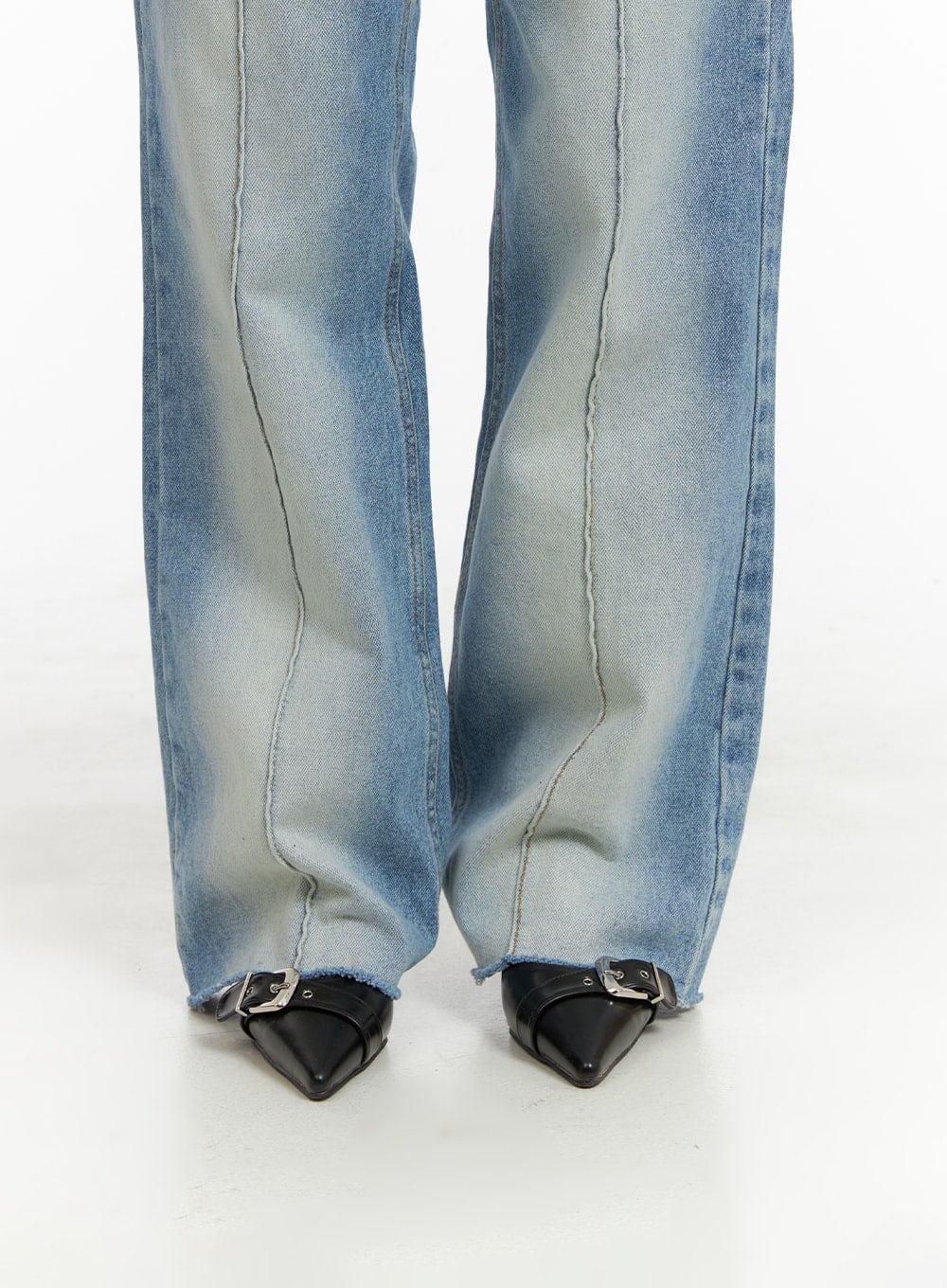 Denim Stitching Wide Fit Straight Jeans CA402 in blue, lower leg close-up on model, highlighting wide straight hem with raw frayed edge, front stitching seam, and washed fade, with black buckle flats.