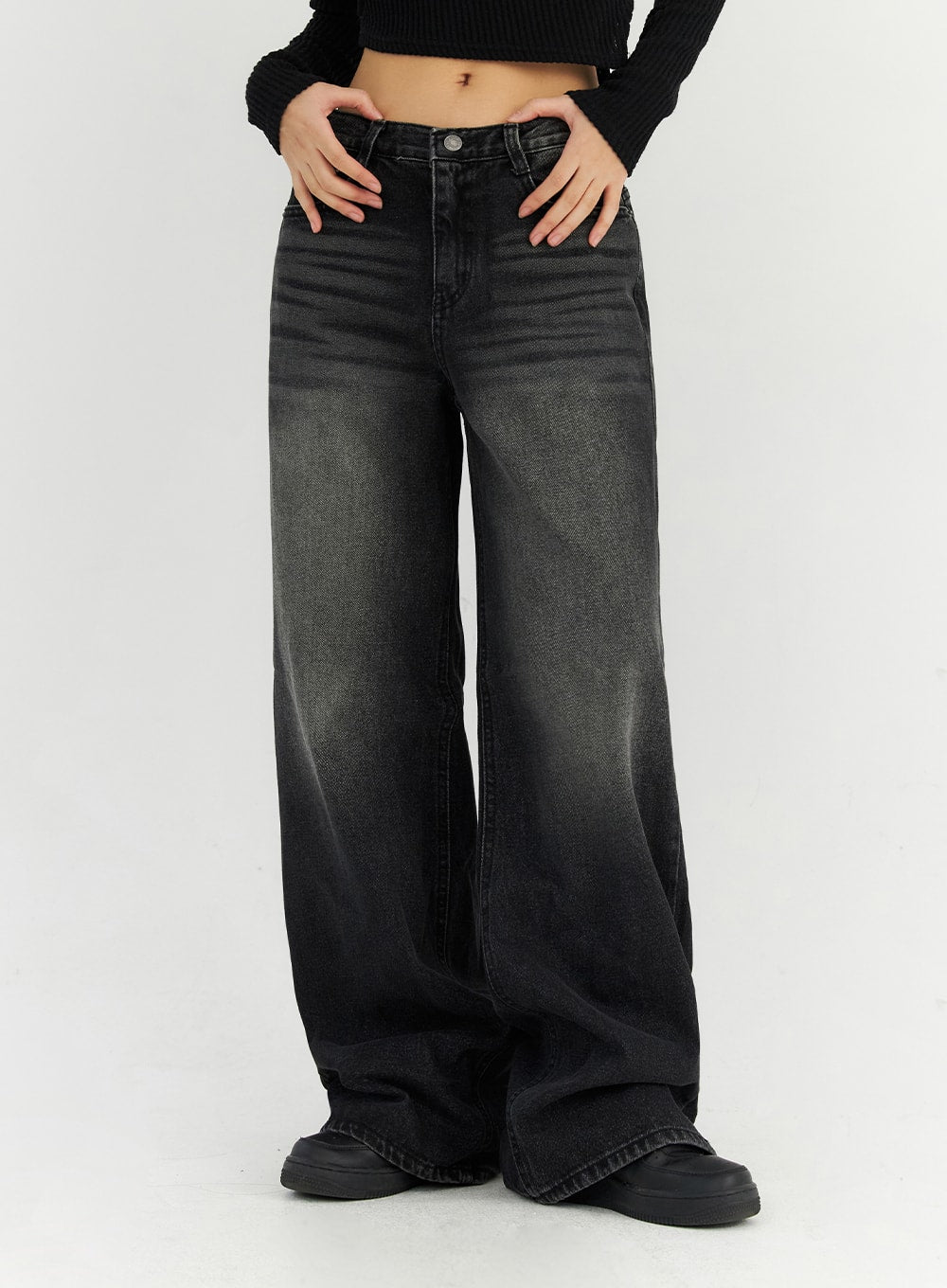 Back Slit Washed Wide Leg Jeans CN306 in Black, waist-to-hem close-up on model, low-rise button fly, faded washed finish, ultra-wide leg drape over chunky black sneakers.