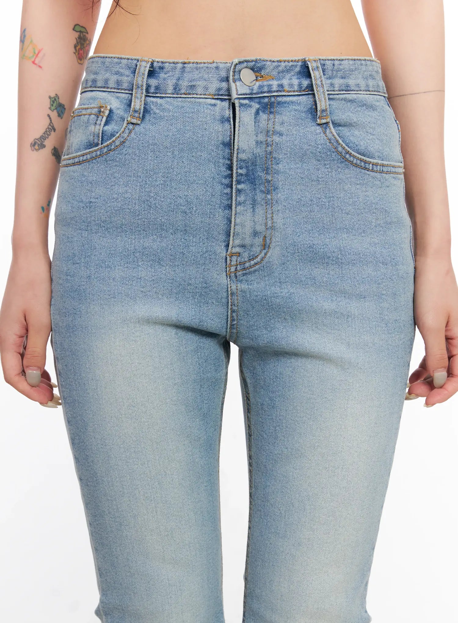 Byeol Washed Flare Denim Jeans CL525 in light blue, close-up of waistband and front pockets on model, button fly, gold contrast stitching, and faded wash detail.