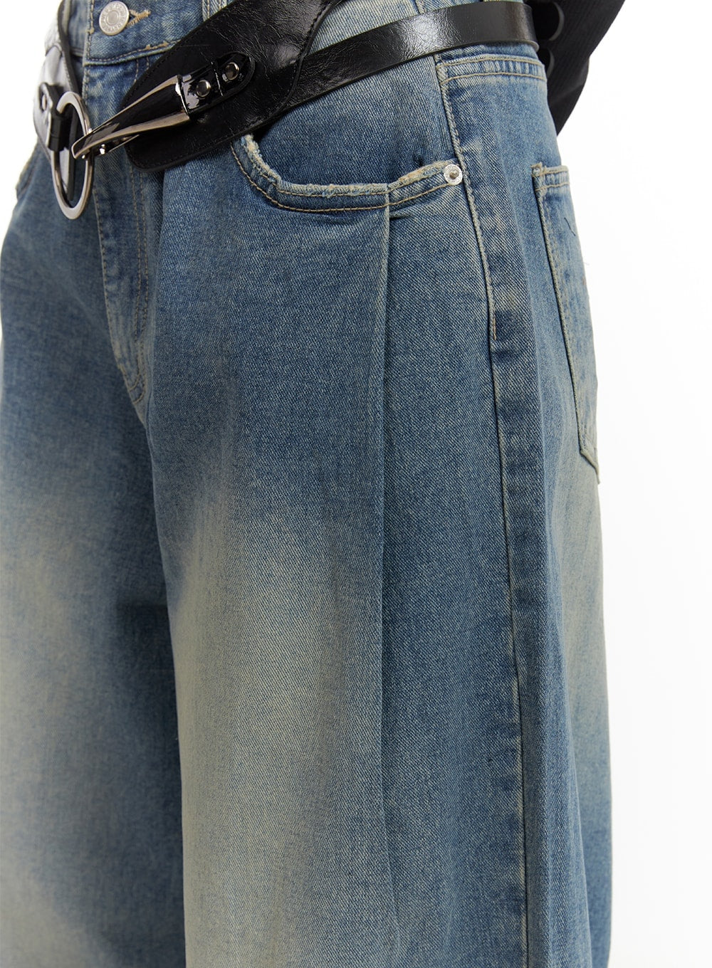 Washed Out Wide Fit Baggy Jeans CA416 in blue, waist close-up on model, front coin pocket, center pleat seam, and washed denim texture with black statement belt detail.