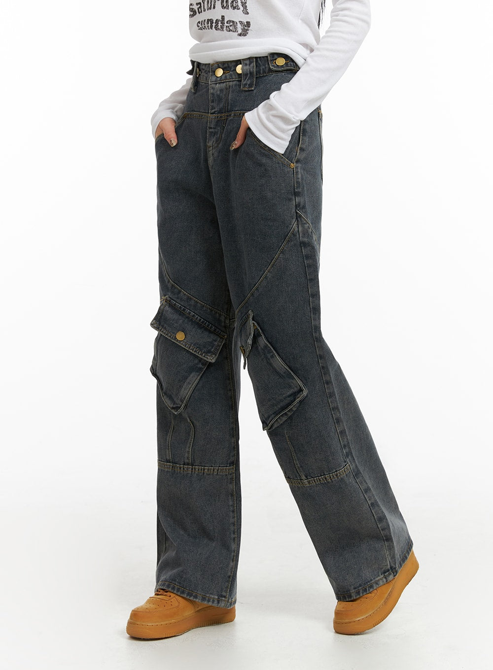 Mid Waist Cargo Jeans CJ411 in dark blue, close-up side shot on model showing waistband snap buttons, angular seams, and large snap-flap cargo pockets on washed denim.
