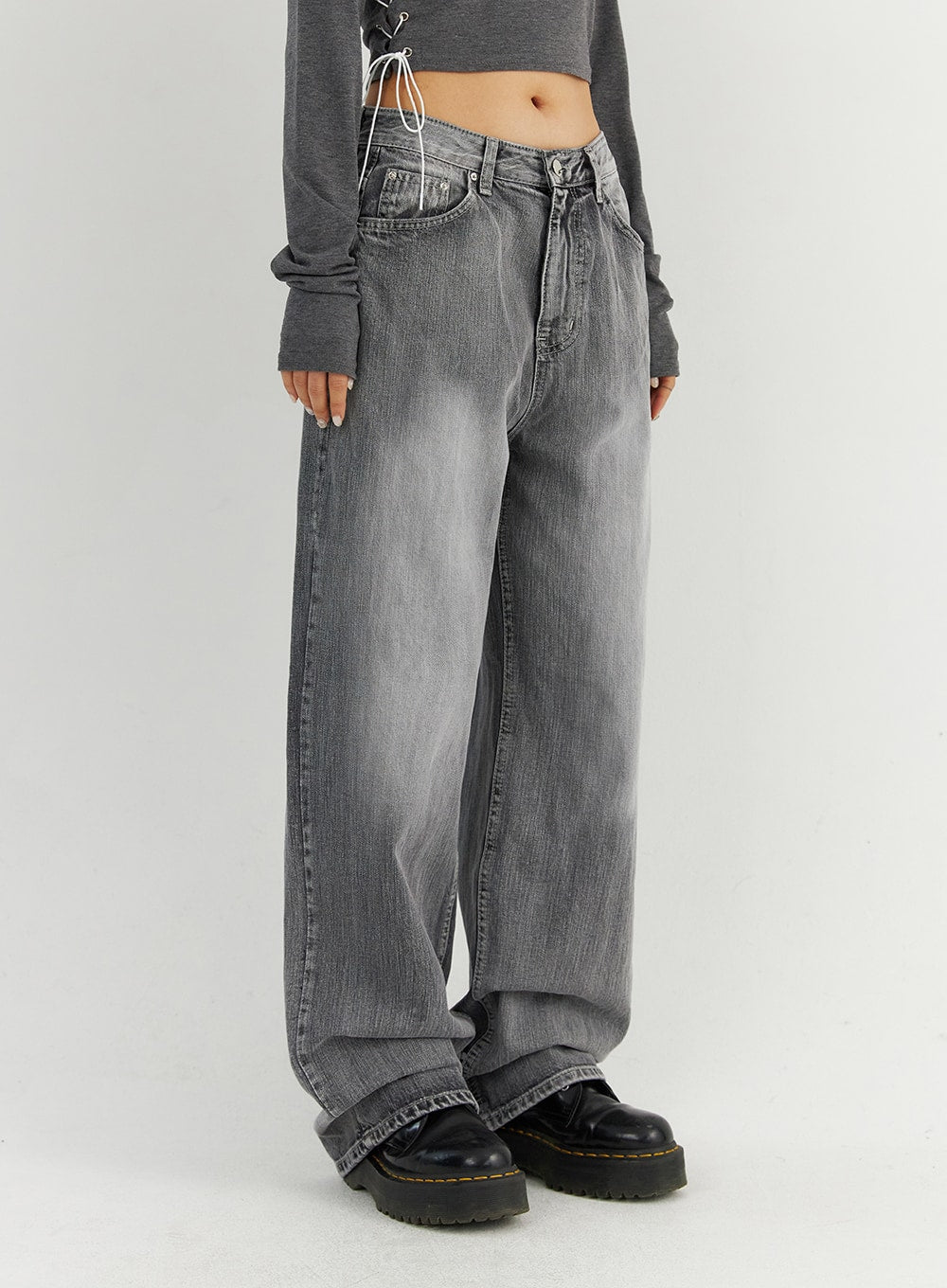 Grey Washed Wide Leg Jeans CO323 in Gray, side close-up on model, showing low-rise waistband, front pocket detail, and oversized wide-leg drape with washed cotton denim texture.