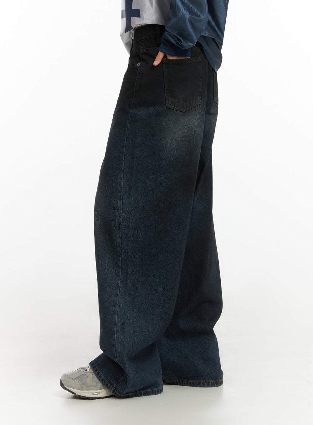 Imogen WashedSky Loose-Fit Denim IO409 in dark blue, side view on model, wide-leg washed denim with back pocket label detail and subtle fade, paired with sporty jersey top.