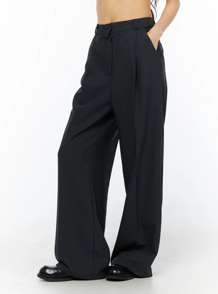 Basic Pintuck Wide Slacks CU522 in dark gray, side view on model, hand in pocket, showcasing wide-leg fall and pintuck crease from hip to hem, black loafers.