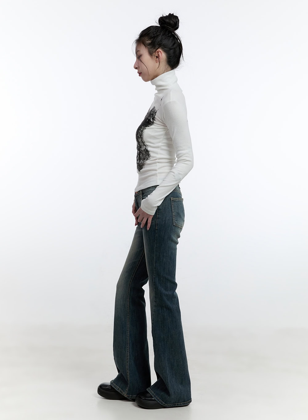 Mallory Skinny Bootcut Jeans CJ520 in blue, full side view on model, slim-fit washed denim highlighting bootcut flare length and silhouette, paired with white turtleneck top.