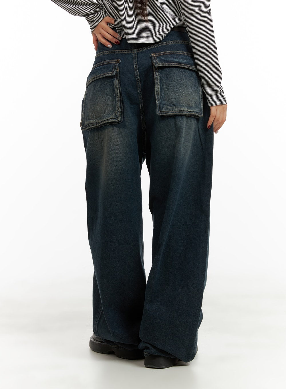 Washed Denim Baggy Jeans CA415 in blue, back view on model, oversized patch cargo pockets, washed denim with fading detail, wide-leg silhouette, paired with striped long-sleeve top.