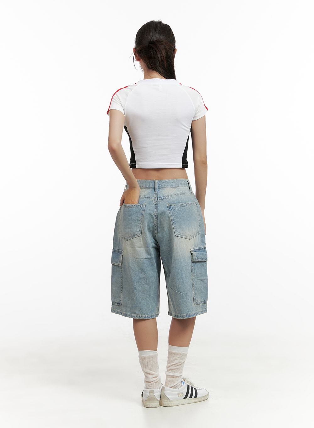 Cargo Baggy Jorts CL431 in light blue, back view on model, washed denim with back pockets and side cargo flap pockets, paired with white crop top and sneakers.