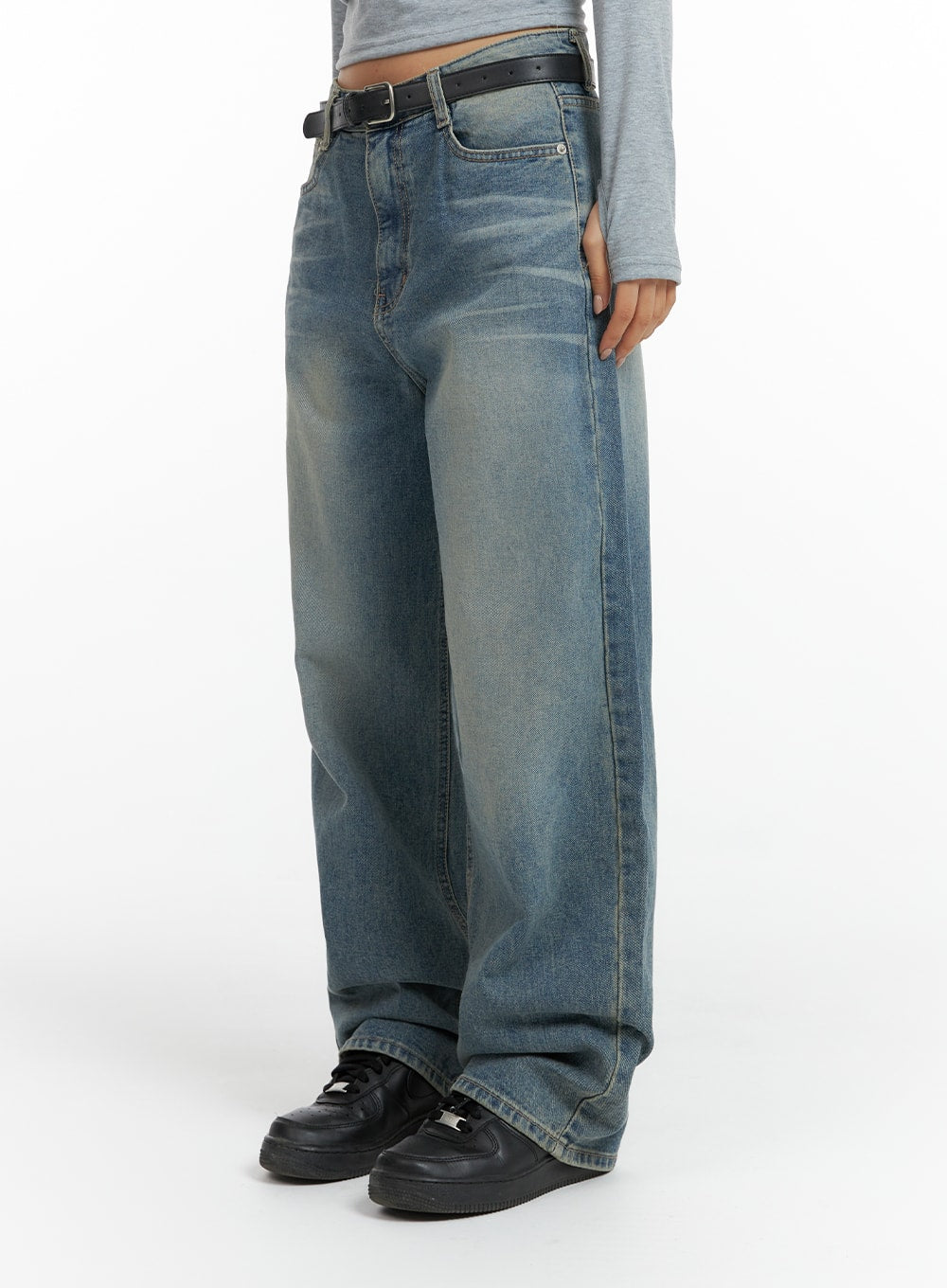 Washed Denim Wide-Leg Jeans CF419 in mid blue, side view on model, wide-leg cotton denim with sun-faded wash, floor-grazing hem, black belt, and black sneakers.