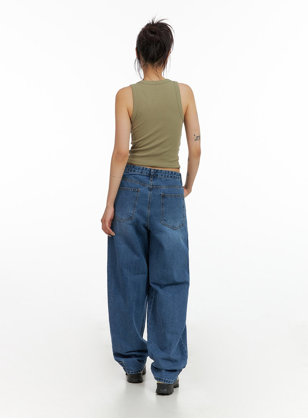 Wide Leg Baggy Jeans CL415 in blue, full-body back view on model, washed denim showing back patch pockets and roomy baggy silhouette, paired with olive tank top.