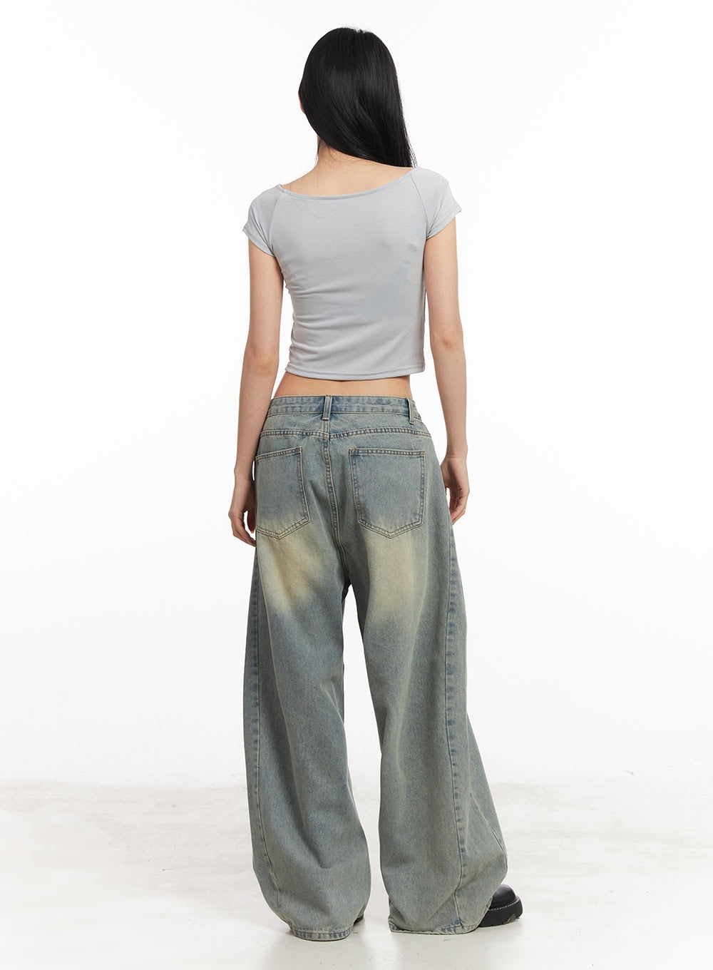 Hillary Washed Wide-Leg Jeans CM504 in light blue, back full-body shot on model, showing back pockets and yellow-tinted wash on wide-leg cotton denim, paired with grey crop top.