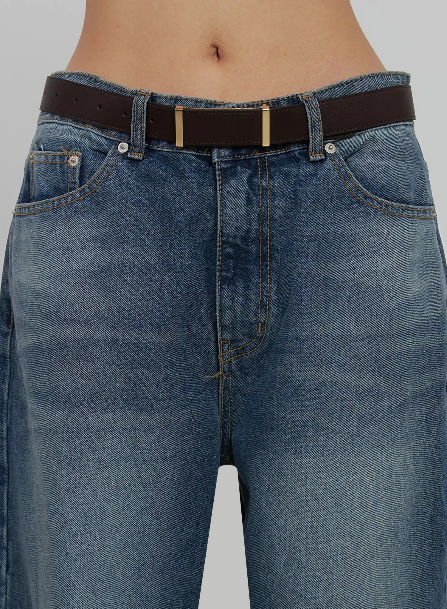Akira Wide Leg Jeans IJ508 in blue, waist close-up on model, showing front pockets, gold-hardware belt loops, five-pocket construction, and brown belt detail.