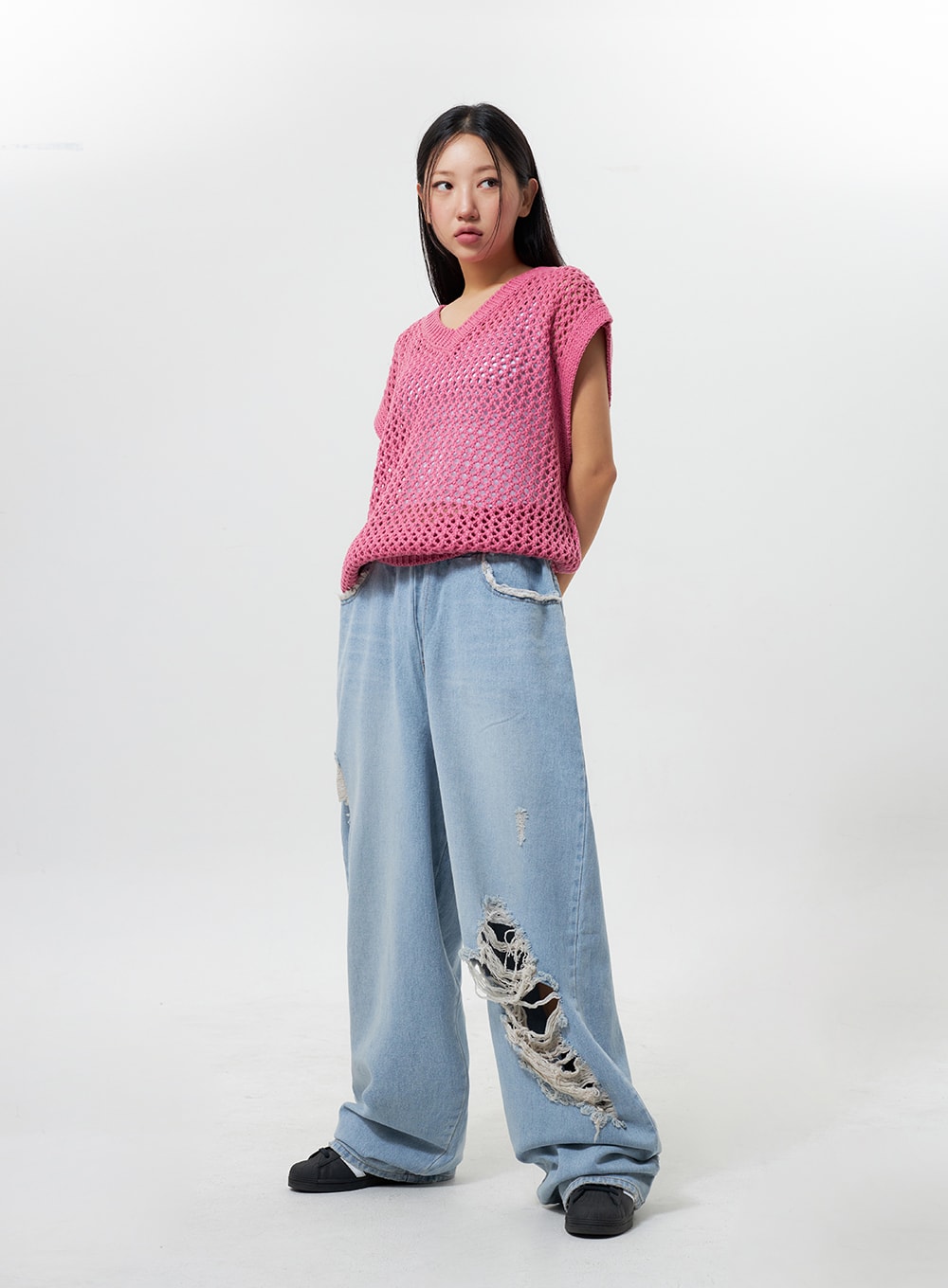 Oversized Ripped Jeans CY324 in light blue, three-quarter front angle on model, wide-leg silhouette with destroyed hem distressing, banded waist, styled with pink crochet top.