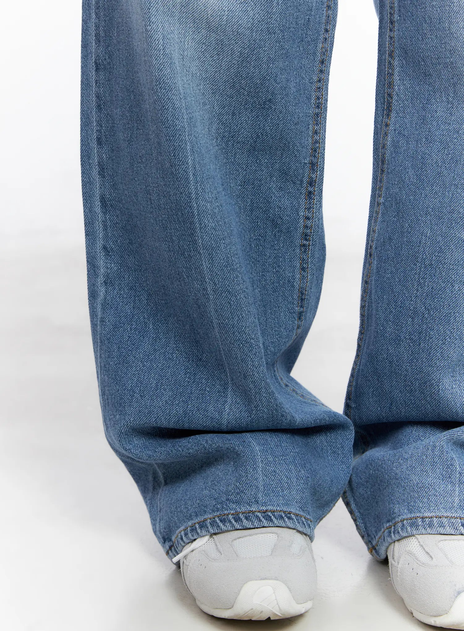 Jung Straight-Leg Washed Jeans CG521 in blue, close-up of hem and leg opening on model, wide straight leg pooling slightly over white sneakers with visible washed denim texture.